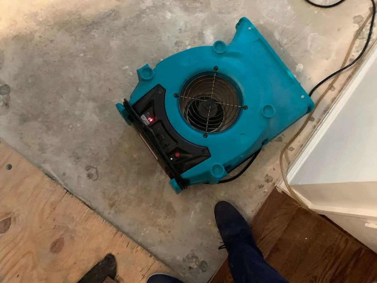 Air mover drying subfloor during Commercial Water Damage Restoration in St. George